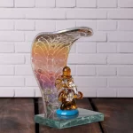 GlassWorld Glass Handicraft Lord Ganesh Idol under Serpent Hood Decorative Showpiece - Available in Assorted Colors